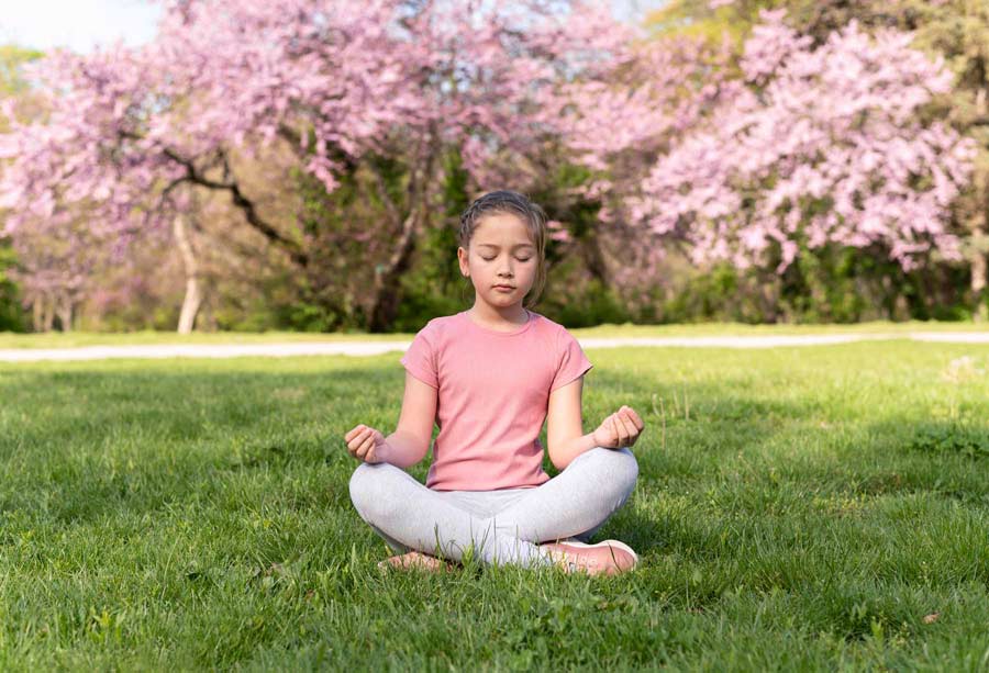 fille qui médite dans l'herbe